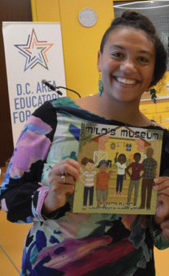 Megan Pamela Ruth Madison holding a children's book and smiling.