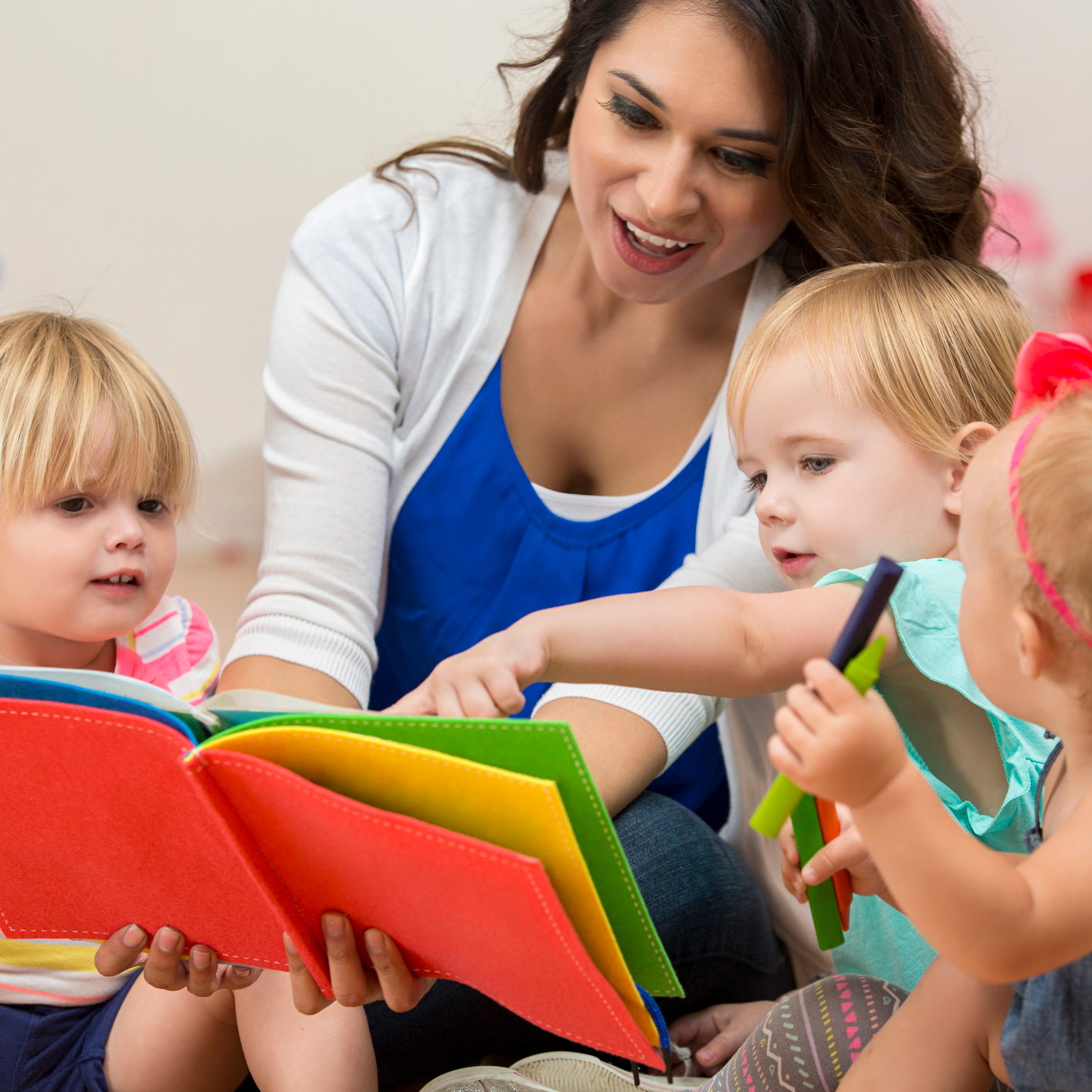 Teacher reading to three preschool students