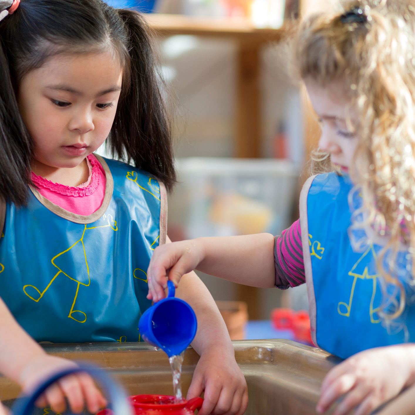 Young girls playing together with water.