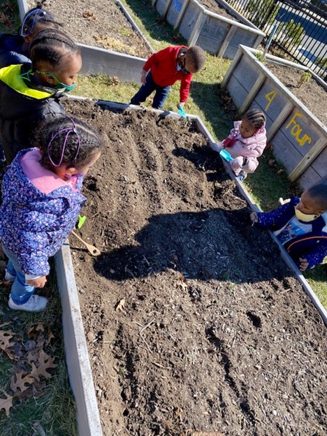 Children investigate a raised garden bed.