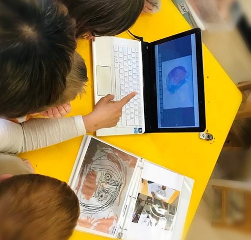 Children point at a computer.