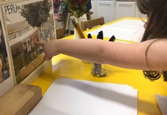 A student points to a picture of children in Peru.