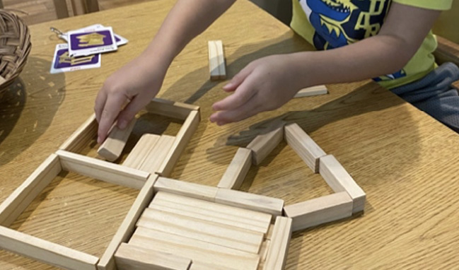 A child makes shapes from wooden blocks.