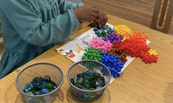 A child sorts multicolored beads.