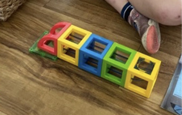 A child creates with interlocking cubes.