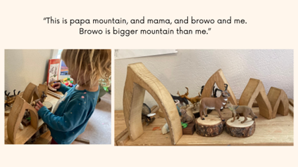 A preschooler uses blocks and plastic animals to build a mountain home.