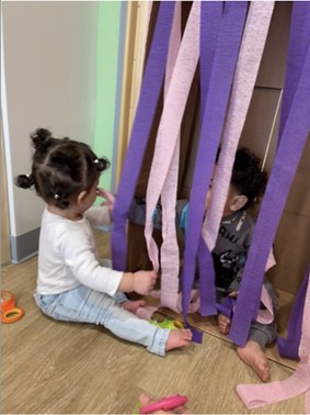 A toddler plays with streamers.