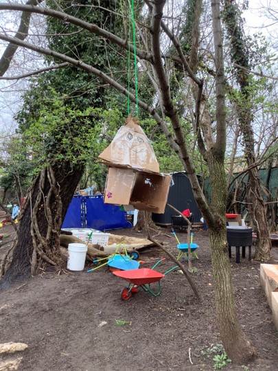 Abel's engineered cardboard bird house, hanging from a tree. 