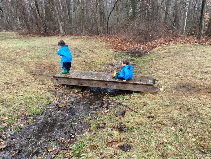 Two toddlers cross a bridge.
