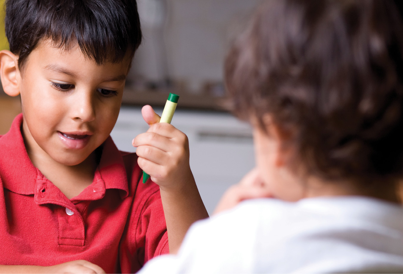 Boy holding green crayon