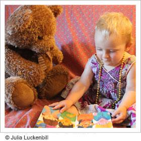 Toddler playing with teddy bear