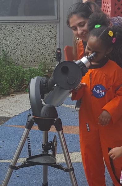 Girl looking through telescope