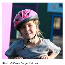 Young girl riding her bike with a helmet