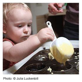 Toddler helping parents cook