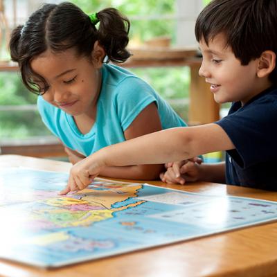 A young boy and girl looking at a map on a table