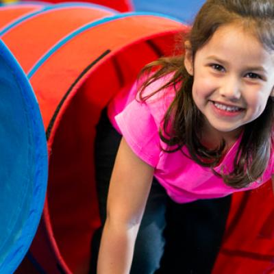 Young girl climbing out of a slide.