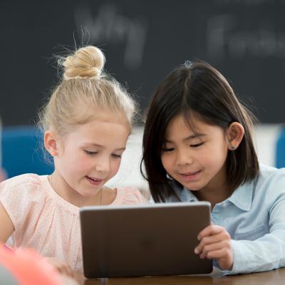 Two kindergarteners working on a tablet device