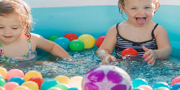 Toddlers playing with toy balls in pool