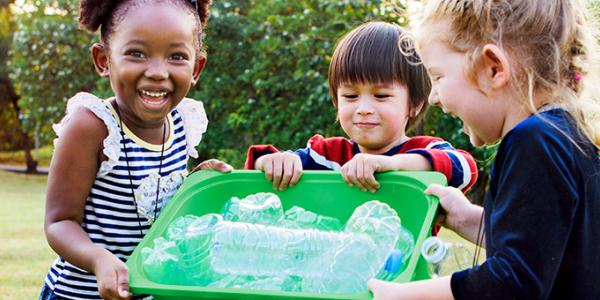 Group of children with a recycling bin