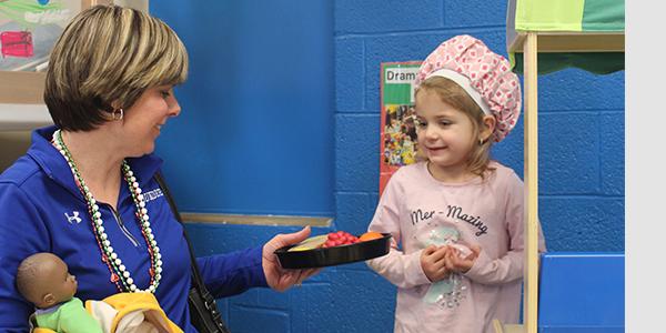 Teacher in a classroom with a preschooler