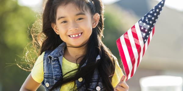 Preschool aged girl holding an american flag