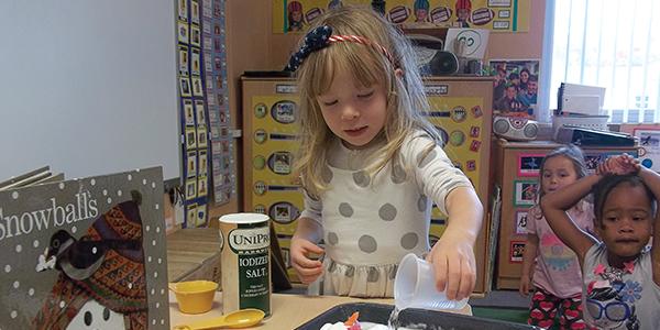 Young child doing a science experiment at table