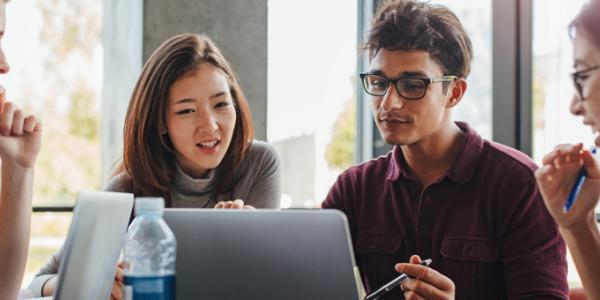 Adult students looking at a computer screen together