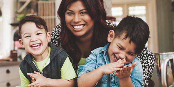 Mother and two young boys smiling and laughing