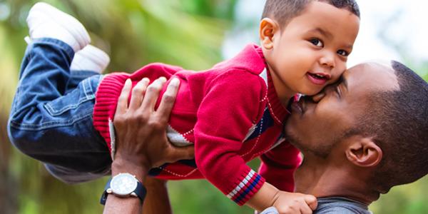 Father holding son in the air outside