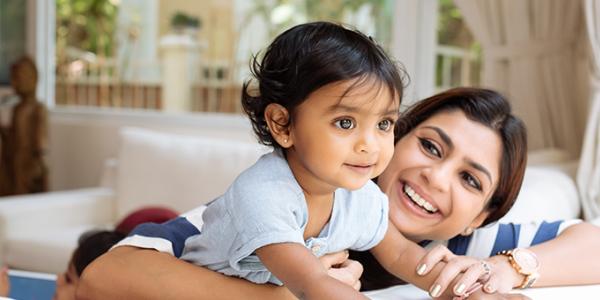 Mother holding and laughing with baby girl