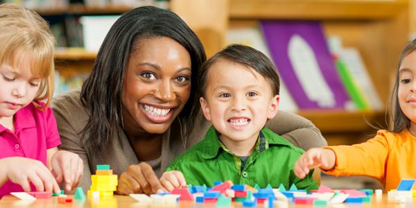 Teacher with four students building blocks