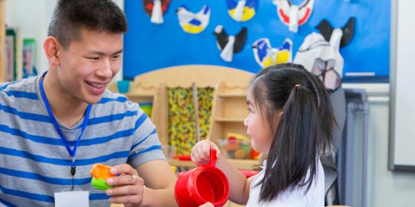 Teacher and student playing in kitchen learning center