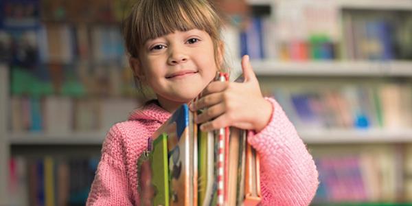 Girl holding a stack of books