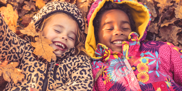 Three girls playing in leaves