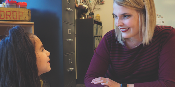 Teacher and student reading a book