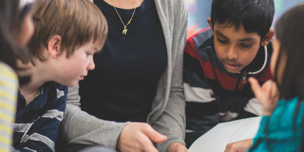 Teacher and students discussing a book