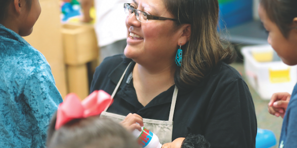 Teacher playing dolls with her students