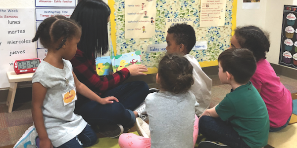 Teacher reading book to diverse students