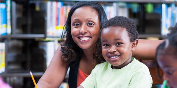 Teacher and child working at a desk together and smiling