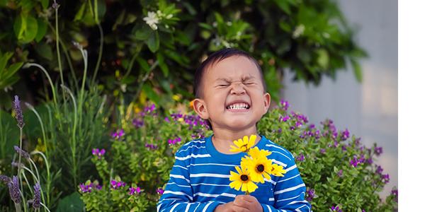a happy child smiling while holding flowers