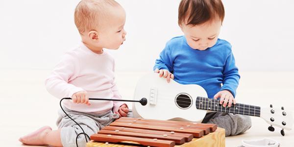 Two young children explore and play with musical instruments
