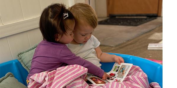 two babies looking at a book