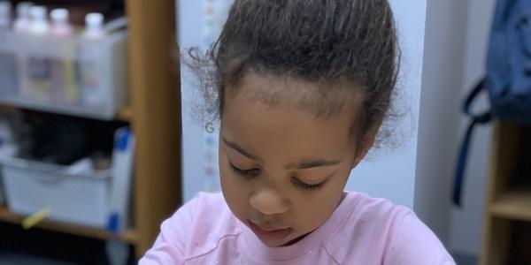 Photo of a young child working on a project in a classroom