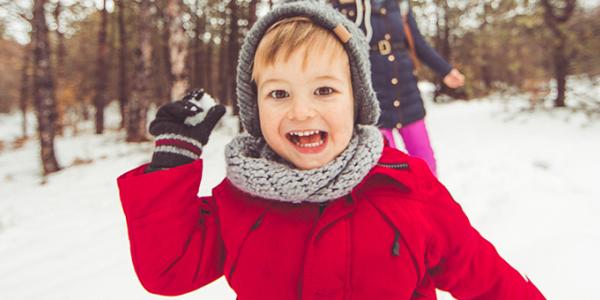 Young boy throwing a snow ball outside