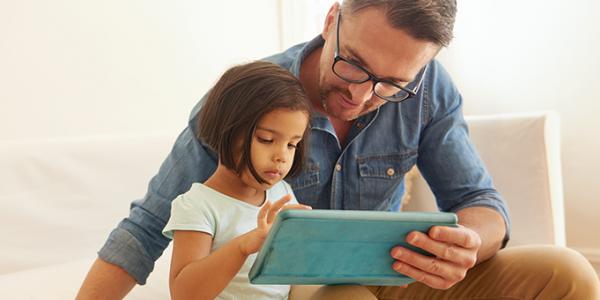Father and daughter holding a digital tablet