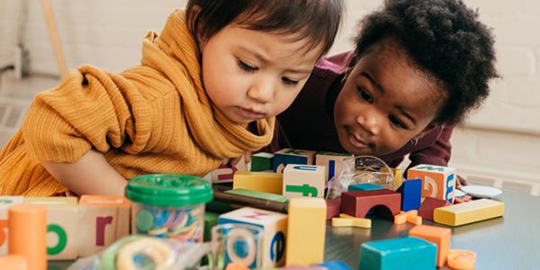 Two toddler girls playing with blocks