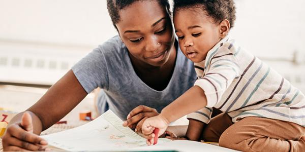 Toddler and mother reading a book 