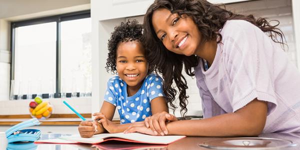 Mother and daughter at the kitchen table doing homework