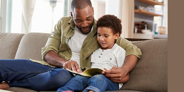 Father and son reading on couch