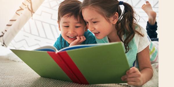 Young boy and girl read a book together